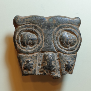 A bronze buckle in a shape of owl depicts Peter