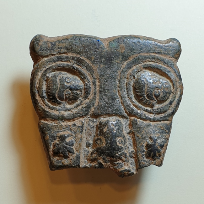 A bronze buckle in a shape of owl depicts Peter